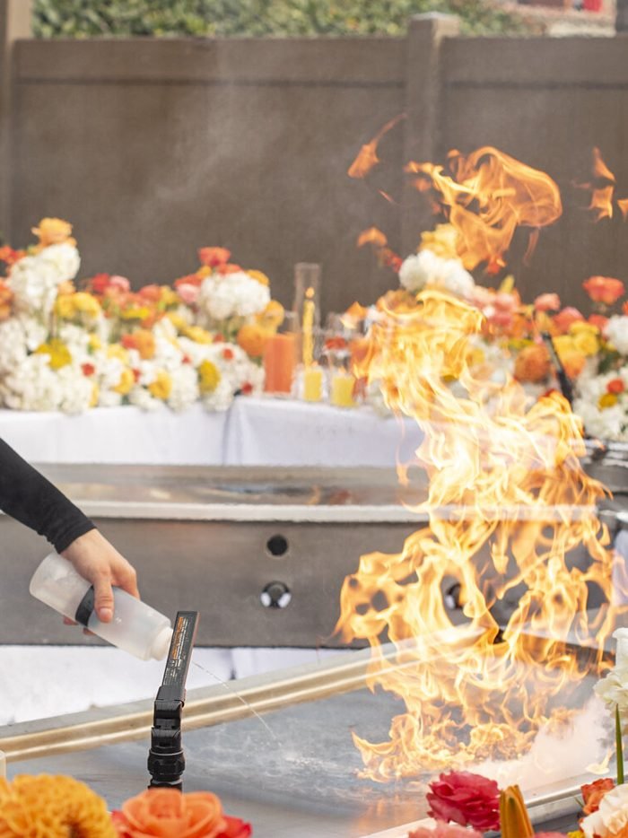 A chef sending up a flame at the grill